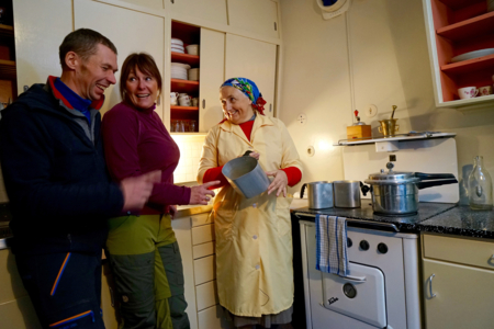 Hushjelpa i 50-tallshuset viser frem datidens kjøkkenredskap.
