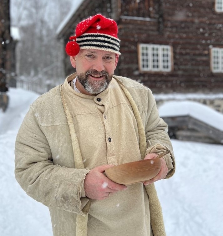 Mann med nisselue og grøtskål